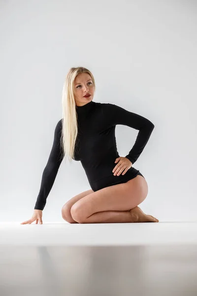 Studio Porträtt Sportig Blond Kvinna Svarta Kläder Sitter Golvet Vit — Stockfoto