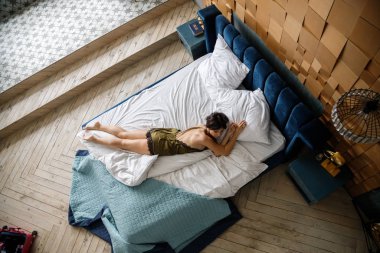 İç çamaşırlı, yatakta poz veren güzel esmer manken.