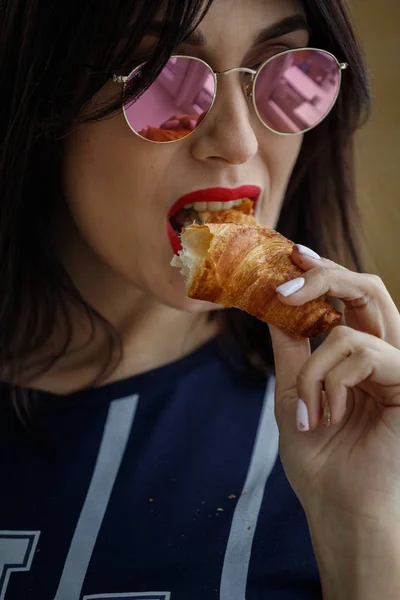 Vacker Brunett Flicka Glasögon Äter Croissant Lägenhet Interiör — Stockfoto