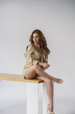 Güzel bir kız. Gömlekli ve iç çamaşırlı seksi sarışın. Oda içinde poz veriyor. 