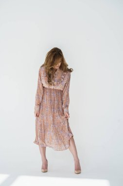 Beyaz bir arka planda poz veren güzel, seksi sarışın kız.