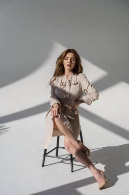 Beyaz bir arka planda poz veren güzel, seksi sarışın kız.