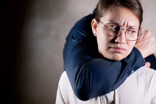 O homem por trás da menina agarra com uma mão forte, a menina não pode fazer nada sobre isso. A violência está a acontecer — Fotografia de Stock