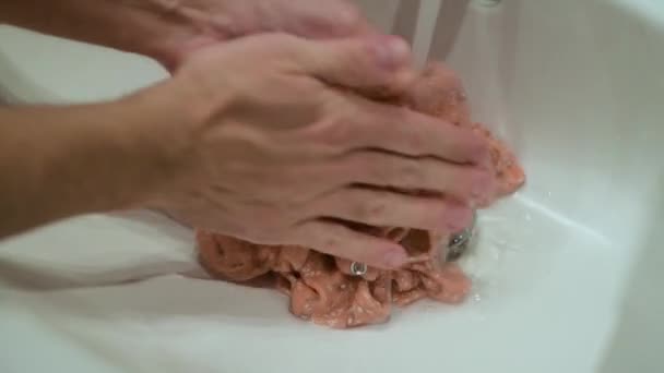 Babyhemd im Waschbecken mit den Händen waschen — Stockvideo