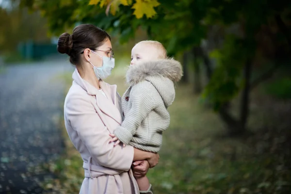 Anne tıbbi maske ve bebek takıyor. — Stok fotoğraf