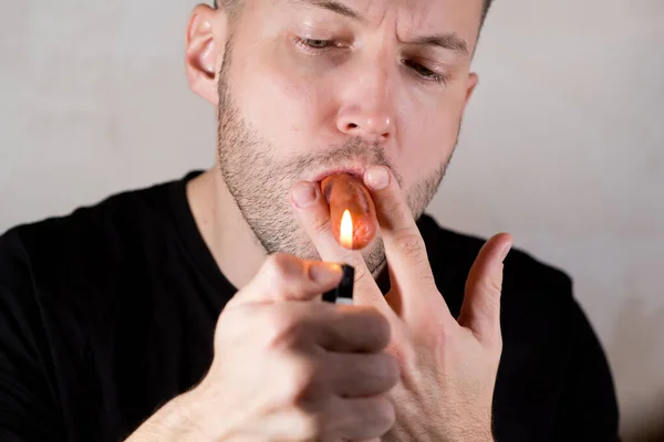 Небритые мужчины держат сосиску во рту, как сигару. — стоковое фото