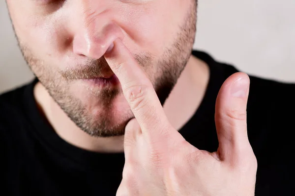 Hombre se mete un dedo en la nariz — Foto de Stock