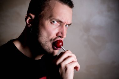 Tıraşsız adam şeker yalıyor