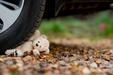 teddy bear under the car wheel clipart