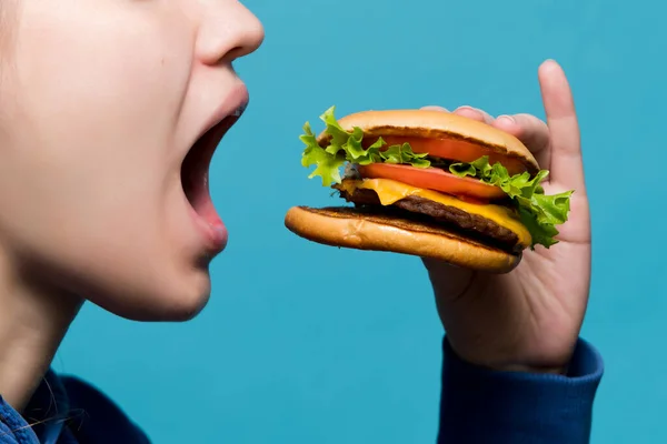 Крупним планом, як бургер потрапляє в рот дівчини — стокове фото