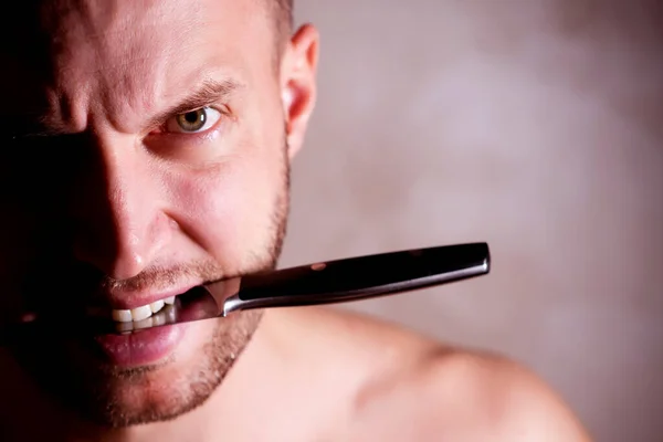 Homem segurando uma faca em seus dentes, espaço de cópia — Fotografia de Stock
