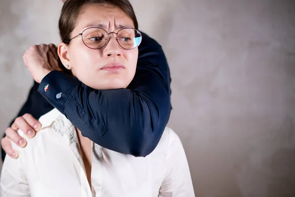 Un hombre sostiene a una chica con una camisa con un agarre de fuerza — Foto de Stock