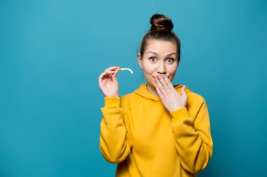 Sweatshirt 'lü bir kız, zayıf iktidarın ve kıkırdamanın sembolü olarak eğik bir sigara tutuyor.