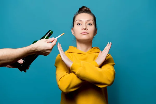 Menina em uma camisola amarela recusa álcool e cigarros — Fotografia de Stock