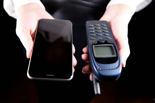 Девушки руки держать старые и новые мобильные телефоны перед ними — стоковое фото
