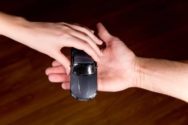 Bir kadın çocuk oyuncağını bir erkeğe verir.