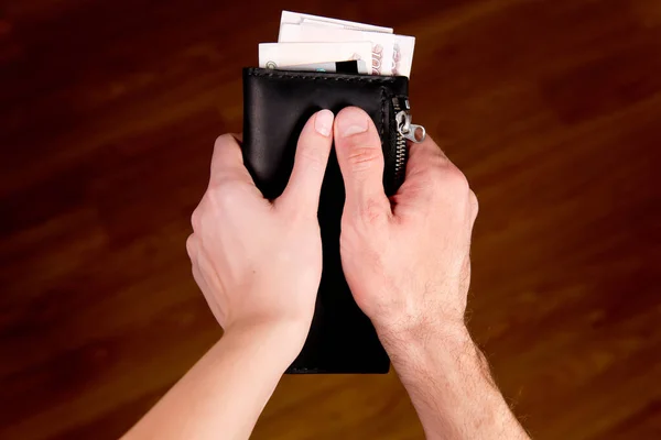 Чоловічі та жіночі руки тримають гаманець як символ загального бюджету — стокове фото