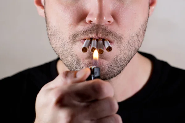 Homem engraçado acende quatro cigarros ao mesmo tempo, close-up — Fotografia de Stock