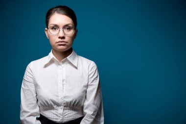 Genç bir ofis çalışanı duygusuz bir şekilde önüne bakıyor.