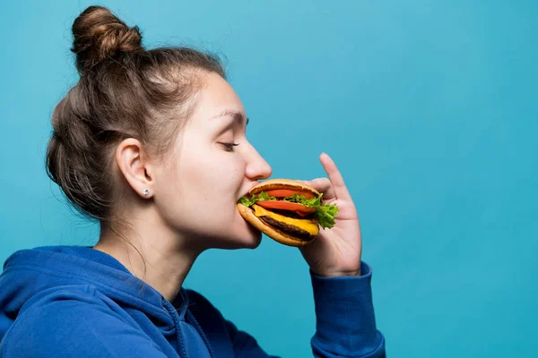 Zijaanzicht van een meisje bijten een sandwich — Stockfoto
