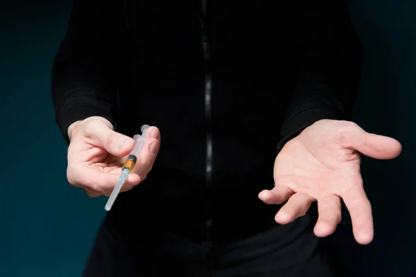 Um homem oferece uma seringa com heroína e requer pagamento, estendendo a mão — Fotografia de Stock