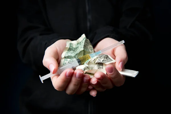 Ženské ruce drží zmačkané dolary a drogy — Stock fotografie