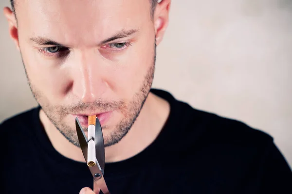 Ongeschoren man met een sigaret met een schaar — Stockfoto