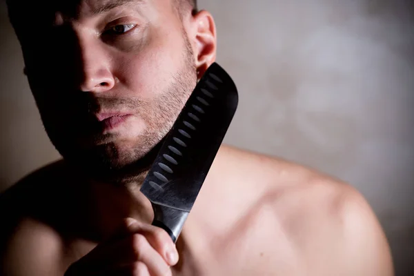 Mann hält sich ein Küchenmesser in der Nähe seiner Stoppeln an die Wange — Stockfoto