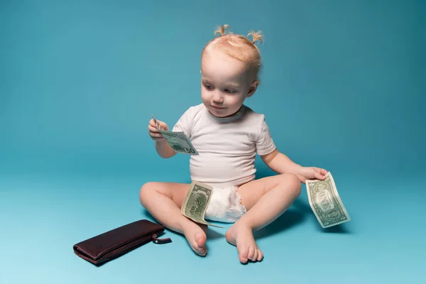 Маленькая девочка играет с деньгами из маминого бумажника — стоковое фото
