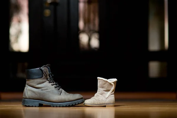 Oude volwassen lederen schoenen staan voor kinderschoenen — Stockfoto