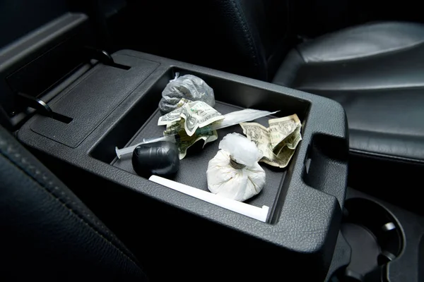 Crumpled dollars and various drugs for testing are in the armrest of the drug dealer s car — Stock Photo, Image