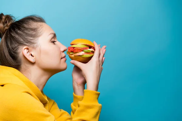 Menina gosta do cheiro de um sanduíche de dieta feita de bagas e frutas — Fotografia de Stock