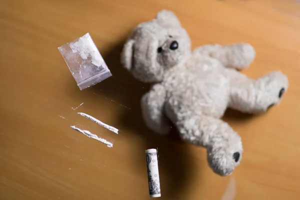 Carris de cocaína, dólar torcido e ursinho de pelúcia — Fotografia de Stock