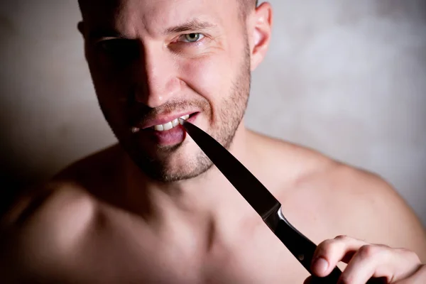 Muž čistí prostor mezi zuby nožem — Stock fotografie