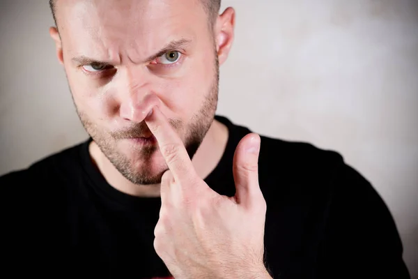 Stern man sticks a finger in his nose — Stockfoto