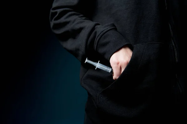 A female hand takes a syringe with a drug from a pocket, close-up. — Stockfoto