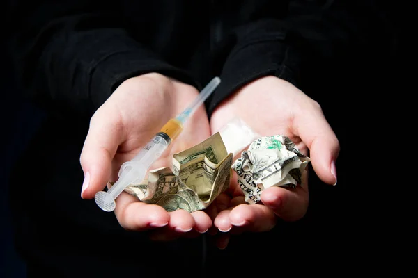 Ženské ruce drží zmačkané dolary a stříkačku s drogou — Stock fotografie