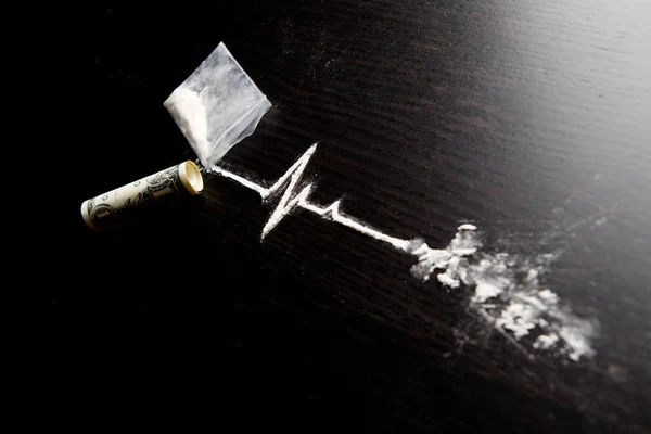 Um trajeto da cocaína na forma de uma linha de vida sai de um saco com uma dose — Fotografia de Stock