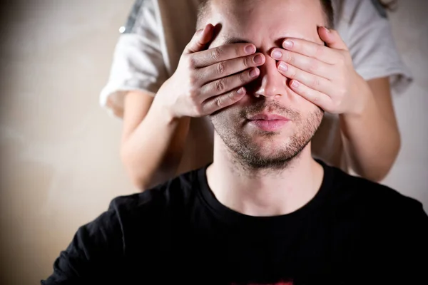 A mulher fecha os olhos ao homem com as palmas das mãos, e o homem senta-se calmamente — Fotografia de Stock