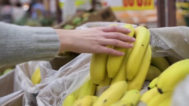 Κορίτσι Παίρνει Ώριμες Μπανάνες Στο Μανάβικο Πάγκο Κοντά Χωρίς Πρόσωπο — Αρχείο Βίντεο