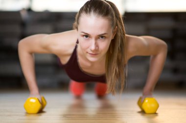 kız dambıl kullanarak şınav çekiyor