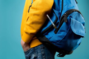 Gençlerin sırt çantasından uyuşturucu çubuğu çıkan bir şırınga.