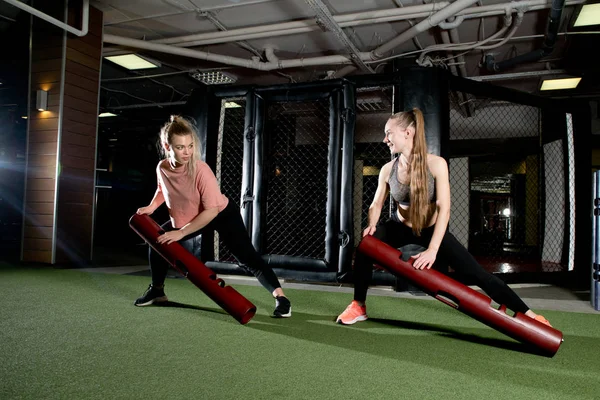 Två flickor utföra övningar med sportutrustning i sportklubben — Stockfoto