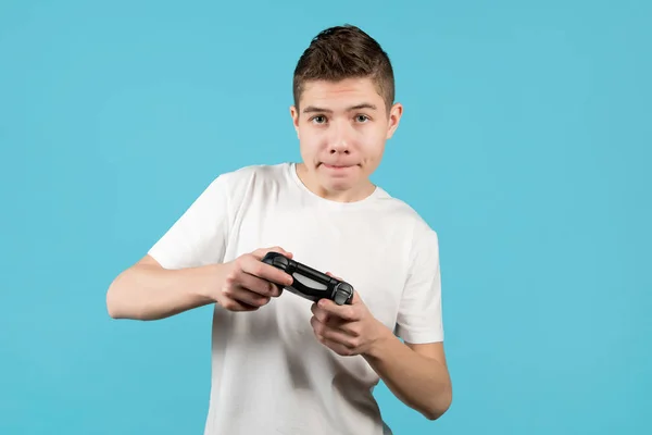 Um jovem com um joystick está focado no jogo — Fotografia de Stock