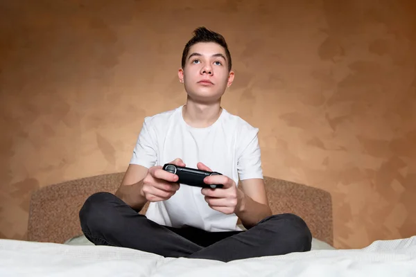 Adolescente com um joystick monitora de perto o jogo, visão frontal — Fotografia de Stock