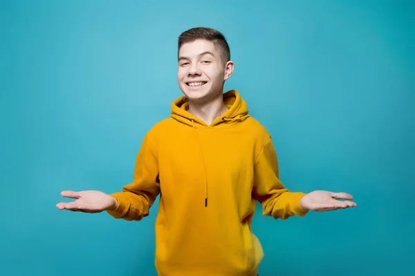 De man houdt zijn handen met zijn handpalmen omhoog en kijkt recht vooruit, glimlachend — Stockfoto