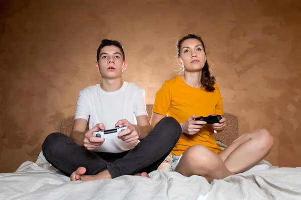 Брат і сестра з ентузіазмом спокійно грають у відеогру, використовуючи джойстики — стокове фото