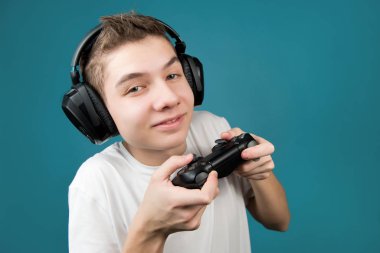 Genç adam, joystick, kulaklık, mavi arka plan