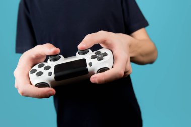 Oyun konsolunun modifiye edilmiş beyaz joystick 'i bir gencin elinde.