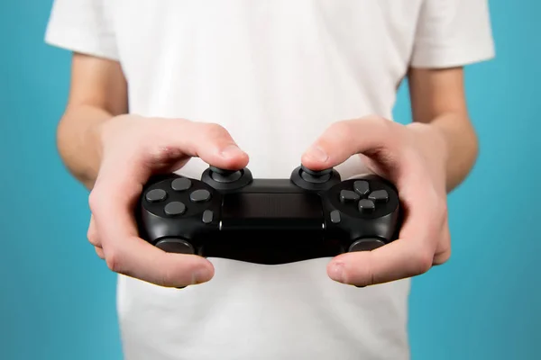 Joystick preto de um console de jogo nas mãos de um adolescente. Fechar — Fotografia de Stock